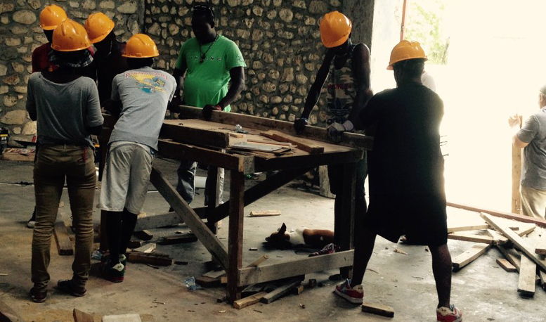 Workers assemble frame components for Port au Prince project. 